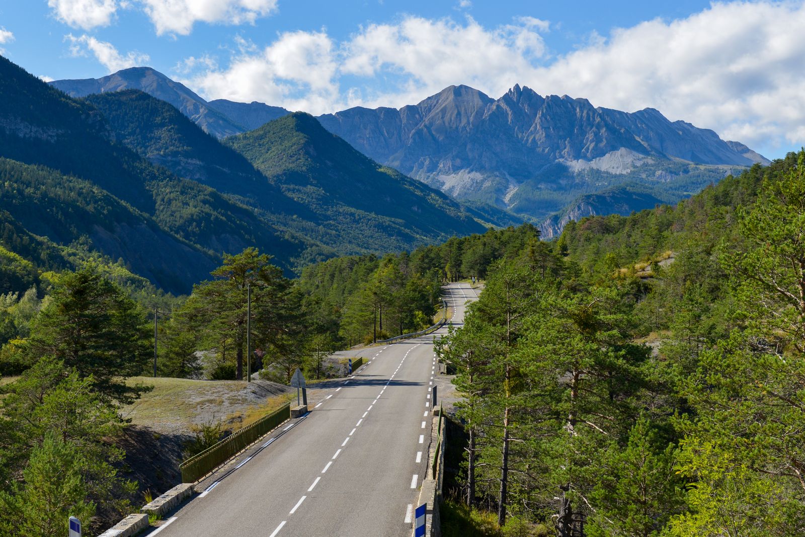 Route sinueuse dans les montagnes des Alpes sous un ciel bleu